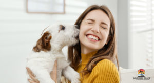 Happy dog licking pet owner's face